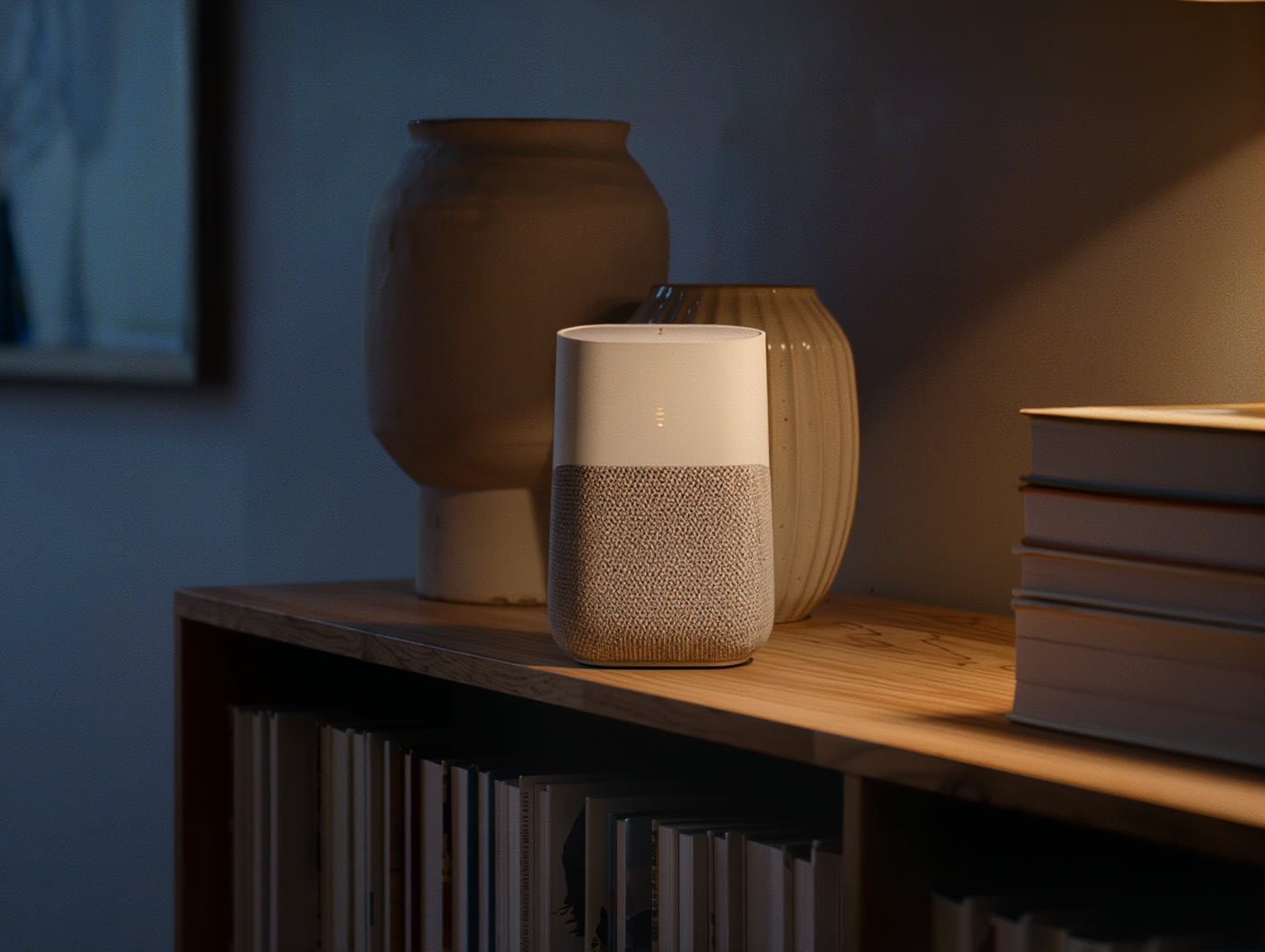 A small fabric-wrapped hub the size of a deck of cards on a wooden bookshelf, one soft amber light.